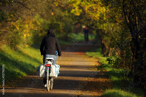 Autumn cycling along a beautiful path among golden red leaves. Road to work by bike. Jesienna jazda na rowerze piękną ścieżką, pośród złotych, czerwonych liści. Droga do pracy na rowerze.