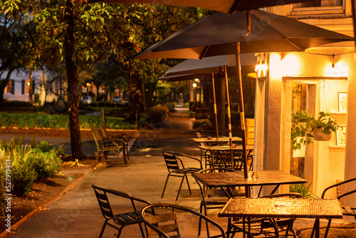 Early evening sidewalk scene in Savannah, Georgia, with empty cafe and restaurant tables