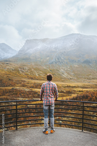 Autumn travel outdoor man looking at view forest and mountains in Norway healthy lifestyle tourist exploring Jotunheimen park
