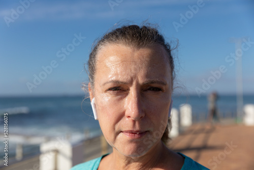 Female jogger looking at camera on seaside