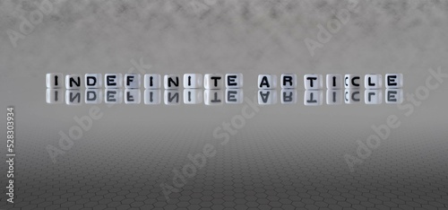 indefinite article word or concept represented by black and white letter cubes on a grey horizon background stretching to infinity