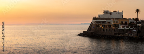 promontory with church of soccorso ischia at sunset