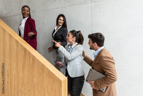 Group of young business people going to cafeteria on lunch break to eat and drink coffee after successful day at work. Office workers going home after working on new project.