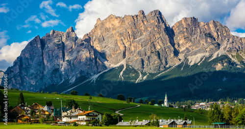 Beautiful view of Cortina d'Ampezzo town with alpine green landscape and massive Dolomites Alps in the background. Province of Belluno, South Tyrol, Italy. Artistic picture. Beauty world