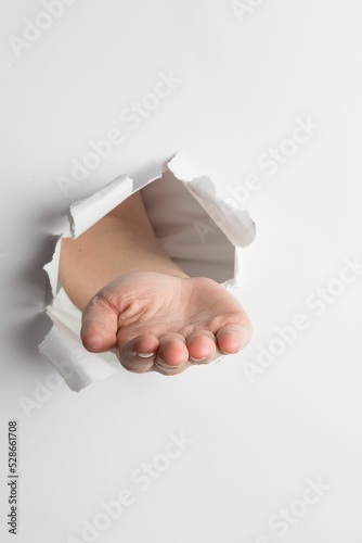 Hand presenting through paper