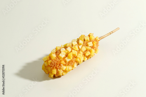 Delicious Crunchy Korean Style Chunky Potato Corn Dogs with Batter and Fried Potatoes. Isolated on Cream Background