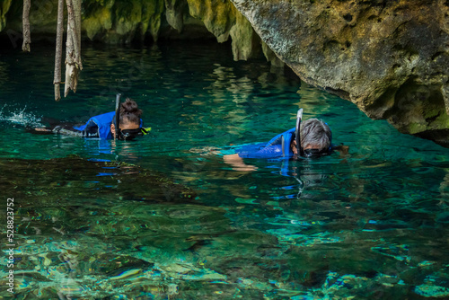 Some people is snorkeling on a cenote in Cancun Mexico