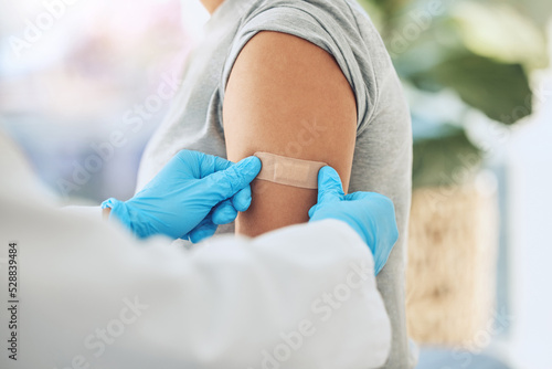 Covid virus vaccination, vaccine and doctor hands with plaster on patient arm in a medical hospital or clinic. Healthcare worker help, trust and safety flu shot antigen for protection against disease