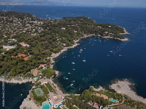 Aerial view of Cap d'Antibes and Billionaire's Bay. Beautiful rocky beach near coastal path on the Cap d'Antibes, Antibes, France. Drone view from above of Côte d’Azur near Juan-les-Pins and Cannes.