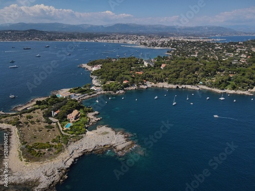 Aerial view of Cap d'Antibes and Billionaire's Bay. Beautiful rocky beach near coastal path on the Cap d'Antibes, Antibes, France. Drone view from above of Côte d’Azur near Juan-les-Pins and Cannes.