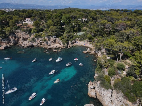 Aerial view of Cap d'Antibes and Billionaire's Bay. Beautiful rocky beach near coastal path on the Cap d'Antibes, Antibes, France. Drone view from above of Côte d’Azur near Juan-les-Pins and Cannes.