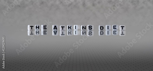 the atkins diet word or concept represented by black and white letter cubes on a grey horizon background stretching to infinity