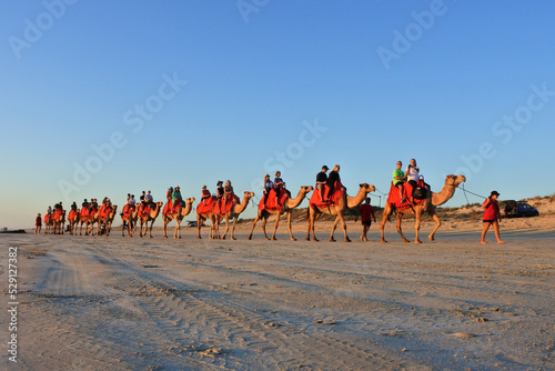Tourists on camel ride convoy on Cable Beach Broome Western Australia