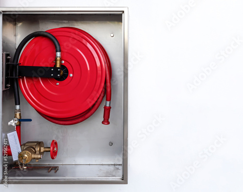 Cabinet open door with fire hose reel inside and copy space