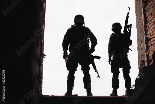 Silhouette photos of the Ukrainian military. Brothers in arms, a man and a woman with weapons in their hands.