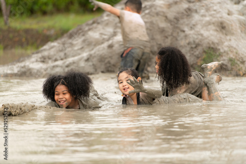 Little girls have fun playing in the mud in the community fields