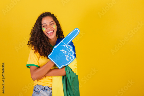 Young black Brazilian woman, soccer fan. pointing right.