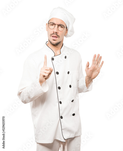 Haughty young chef making a contemptuous gesture