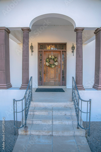Downtown Tucson, AZ- Large carved wooden door with wreath and railings on the sidelights and transom
