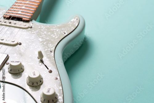 Electric guitar on green table background, close up music concept