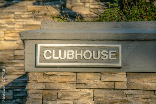 La Jolla, California- Clubhouse label on a wall outside with stones