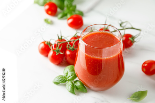 Tomato juice in a glass and fresh tomatoes