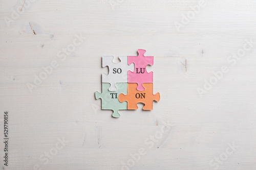 Word Solution spelled with syllables on four matching colorful puzzle pieces