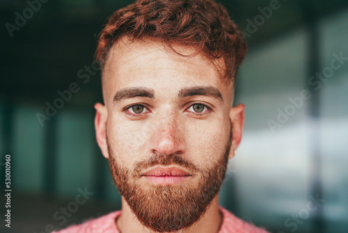 Young happy man looking at camera outdoor - Focus on face