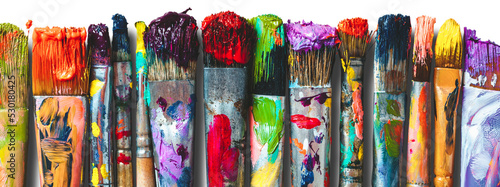 Row of artist paintbrushes closeup. Artistic brushes smeared with paints, isolated.