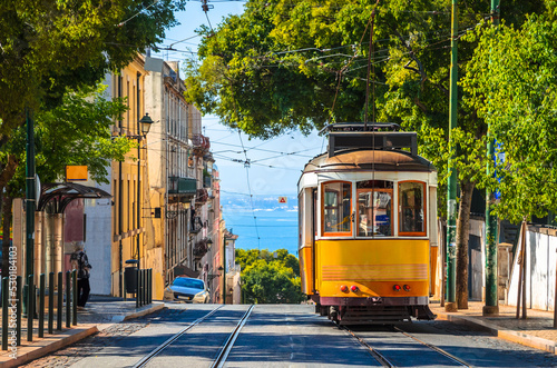 Famous yellow vintage tram in the street of Alfama, Lisbon, Portugal