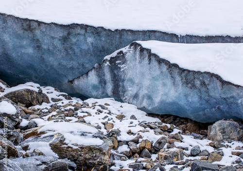 Glacier high in the mountains. A high layer of ice permafrost on a mountain peak.