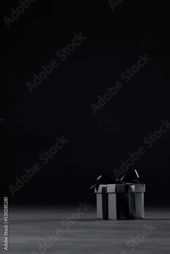 Composition of present with black ribbon on gray background