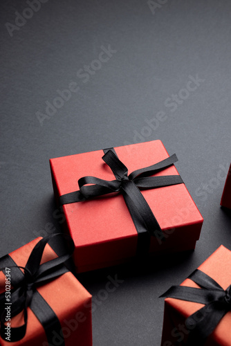 Composition of presents with black ribbons on gray background
