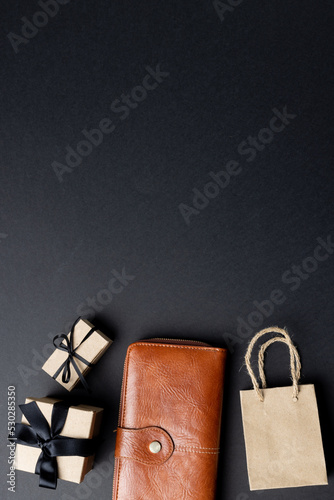 Composition of bag, wallet and presents with copy space on gray background