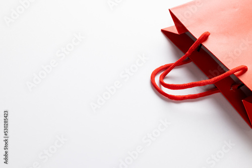 Composition of red paper shopping bag on white background