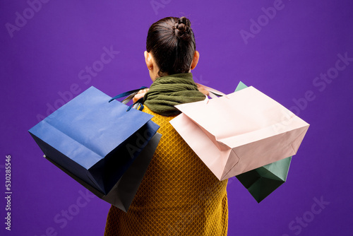 Composition of caucasian woman holding shopping bags on blue background