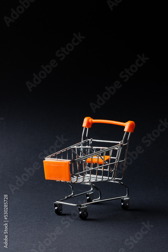 Composition of shopping cart and copy space on gray background