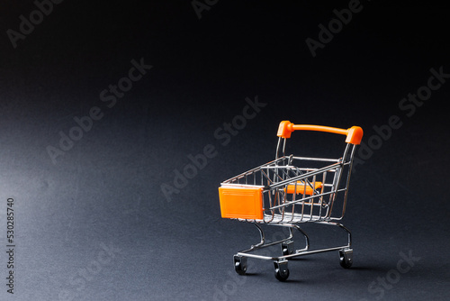 Composition of shopping cart and copy space on gray background