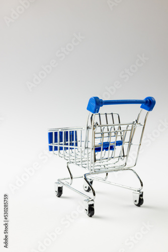 Composition of shopping cart and copy space on white background