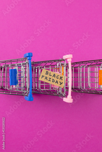 Composition of shopping carts with black friday text on pink background