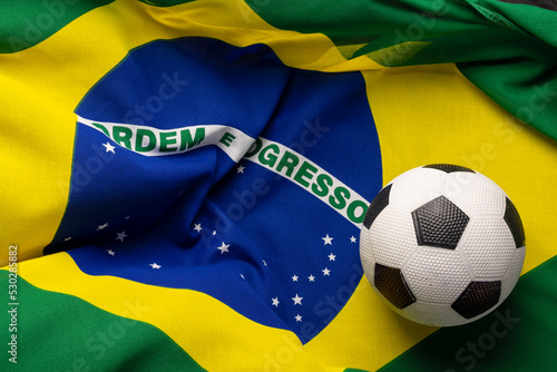 Composition of football over national flag of brazil