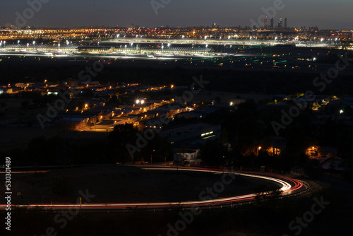 Madrid skyline at night. Barajas airport and 4 towers in the background. Slow shutter of traffic. 