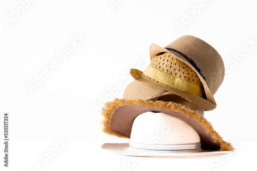 Image of stack of straw hats on white surface