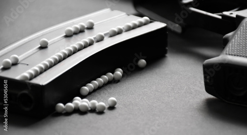 White plastic bullet balls of airsoft gun or bb gun on dark floor, soft and selective focus on white pellets.
