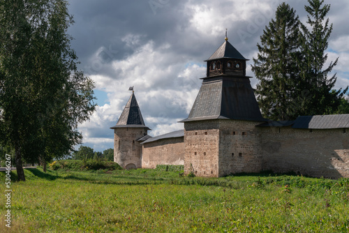 View of the wall of the Holy Dormition Pskov-Pechersk Monastery, Izborskaya tower and Blagoveshchenskaya Tower on a sunny summer day, Pechory, Pskov region, Russia