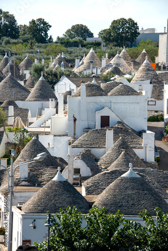  typical trulli houses in Alberobello, Puglia, Italy. Traditional symbols are painted on the conical roofs. A trullo is a traditional Apulian stone dwelling in Itria Valley. 