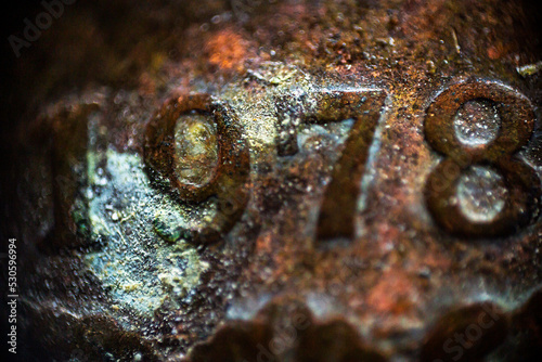 Rusty texture with mold and inscription 1978 on an old coin in macro 