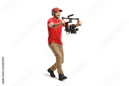 Full length shot of a camera operator walking and using a camera stabilizer