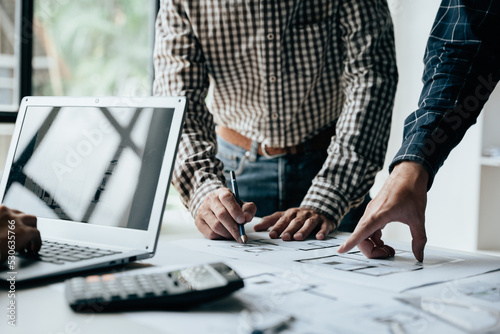 Close up of hands working brainstorming and measuring for cost estimating on paperworks and floor plan drawings about design architectural and engineering for houses and buildings.