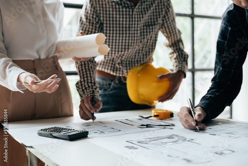 Close up of hands working brainstorming and measuring for cost estimating on paperworks and floor plan drawings about design architectural and engineering for houses and buildings.